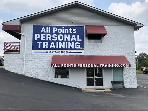 The All Points gym, a white brick building with maroon awnings