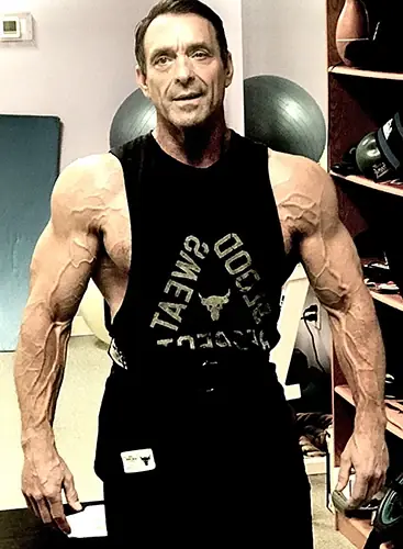 Tim Underwood in the gym at 65 wearing a black tank top